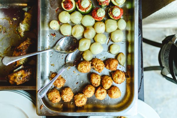 View from above of catering tray with potatoes and meat medallions.